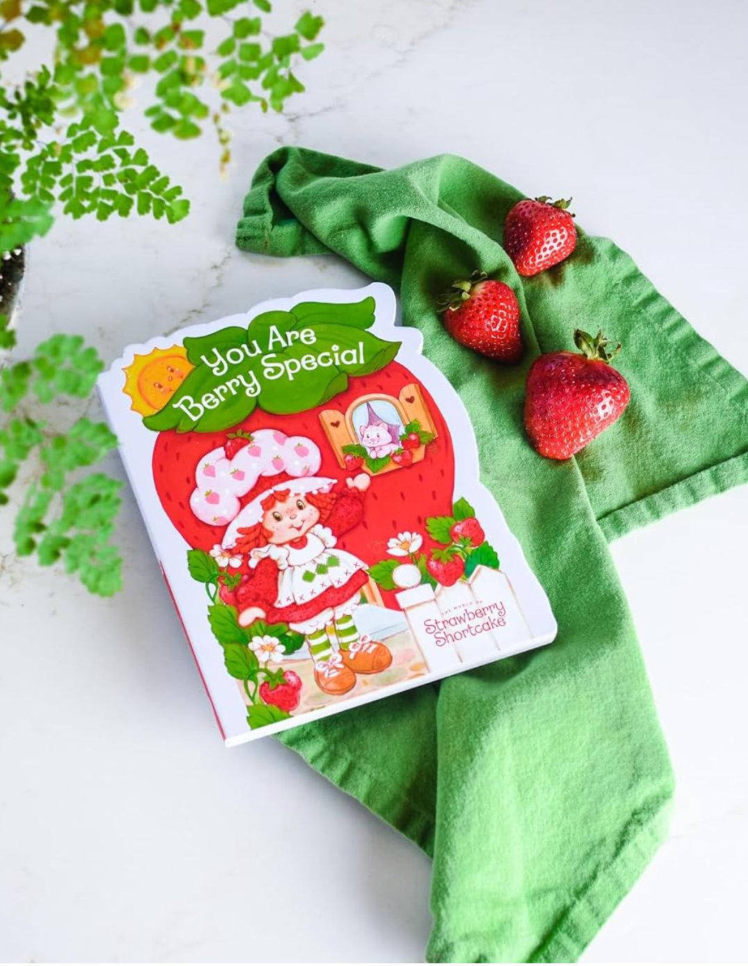 You Are Berry Special board book on a green napkin with fresh strawberries