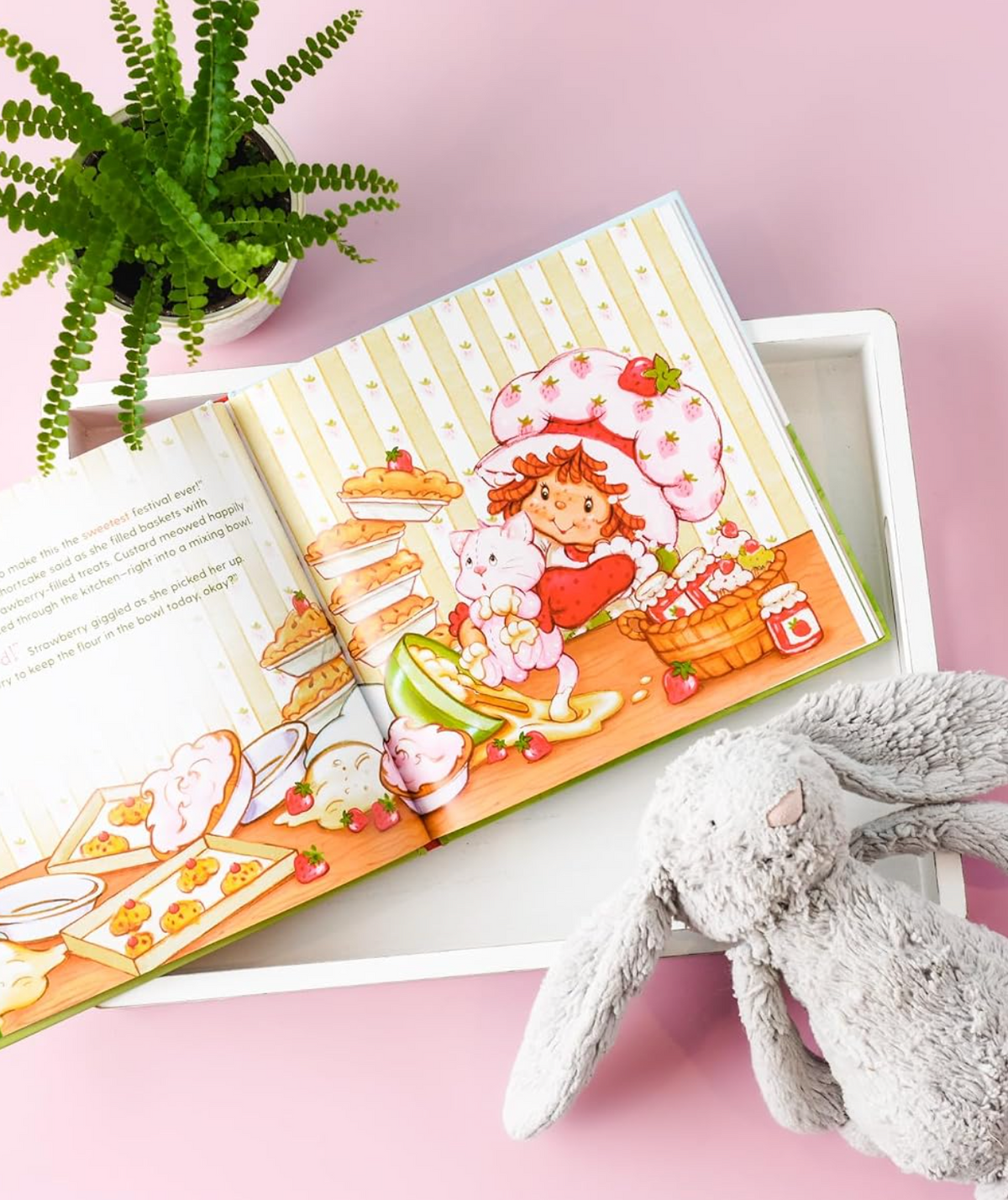 An open Strawberry Shortcake picture book beside a plush bunny